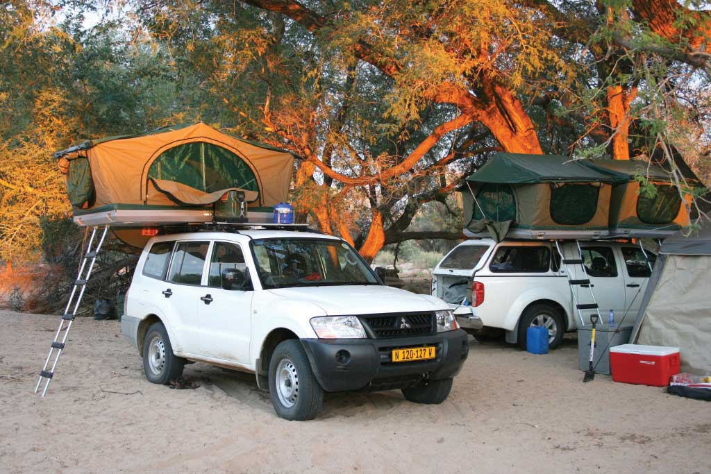 Im Geländewagen die beste Afrika Reisezeit erleben mit Dachzelt unterm Baum schlafen